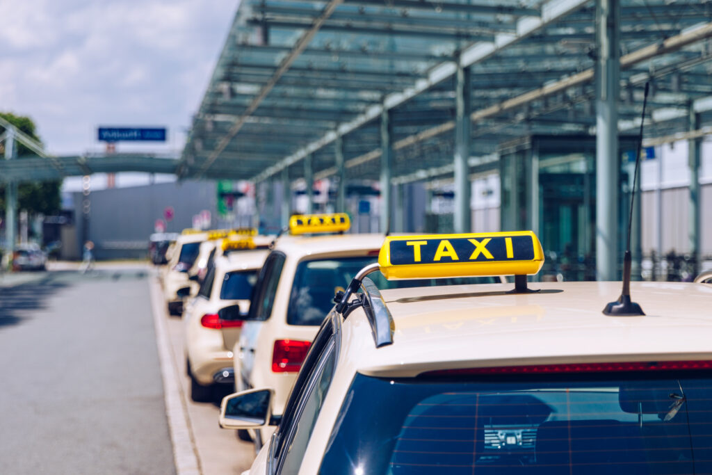 Taxi sign on the roof of a vehicle. Taxi cars on the street waiting for passengers. Selective focused image. Waiting taxi cars in the city.
