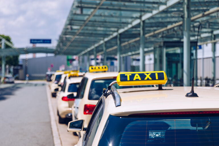 Taxi sign on the roof of a vehicle. Taxi cars on the street waiting for passengers. Selective focused image. Waiting taxi cars in the city.